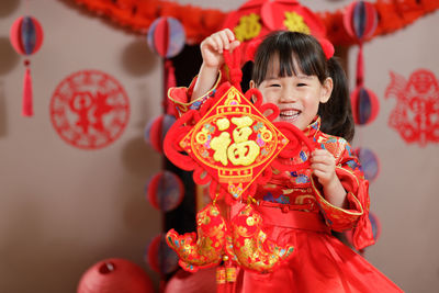 Young chinese girl with traditional dressing up holding  greeting card celebrate chinese new year