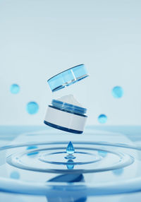 Close-up of water drop on glass against white background