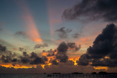 Sunset background and sun beam on the open sea with beautiful clouds.