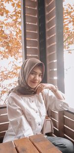 Young woman looking through window in winter