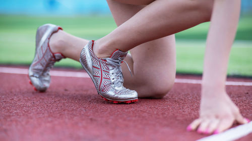 Low section of woman tying shoelace