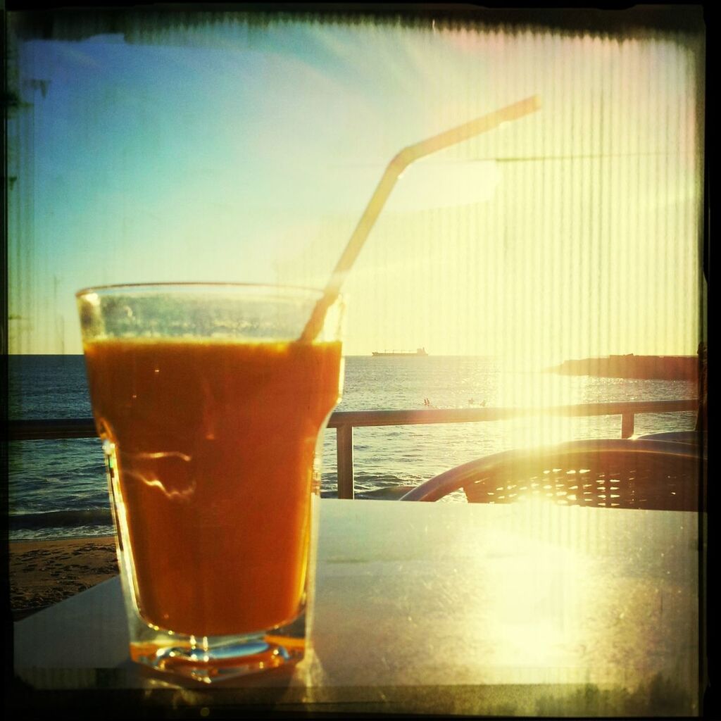 drink, food and drink, refreshment, transfer print, freshness, drinking glass, table, auto post production filter, close-up, drinking straw, sunset, water, alcohol, cocktail, sea, still life, indoors, beverage, horizon over water, focus on foreground