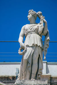 Low angle view of statue against blue sky