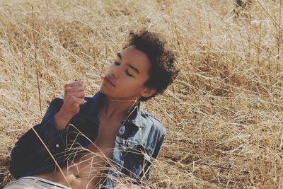 Portrait of young woman sitting on field