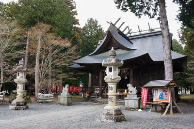 Temple against building and trees against sky