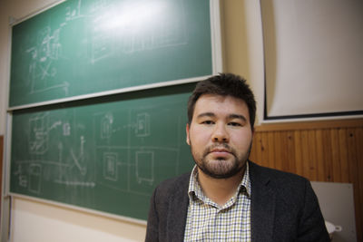 Portrait of young man standing in office