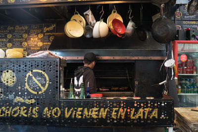 Rear view of man working on barbecue grill