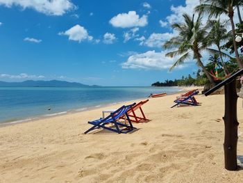 Chairs on beach against sky