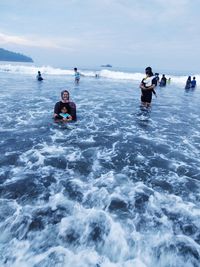 People enjoying in sea against sky