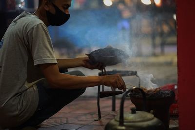 Side view of man preparing food