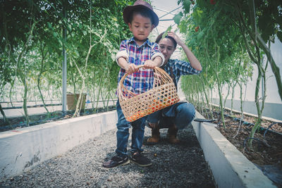 Full length of boy holding plants