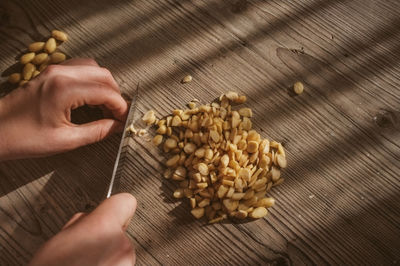 Cropped image of woman cutting nuts in kitchen