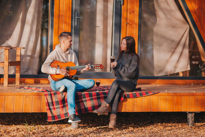 Full length of a woman playing guitar
