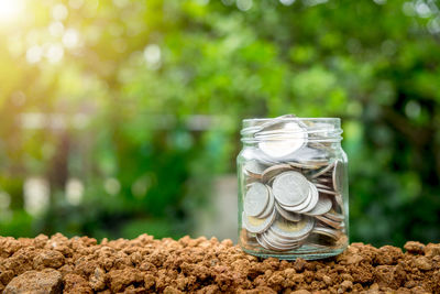 Close-up of coins in jar on table