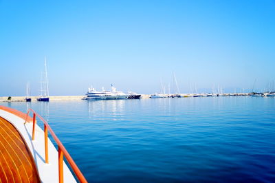 Sailboats sailing in sea against clear blue sky