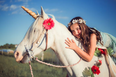 Girl riding horse on field