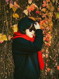 Woman holding autumn leaves in field