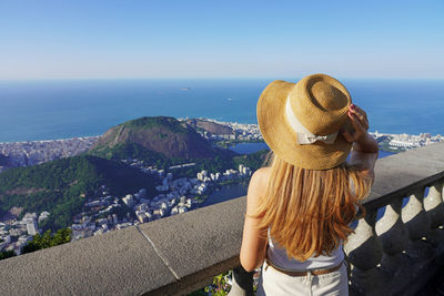 Traveler girl on corcovado mountain looks cityscape of rio de janeiro, brazil.
