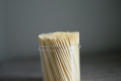 Close-up of toothpicks in glass container on table