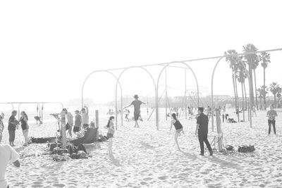 People on beach against clear sky