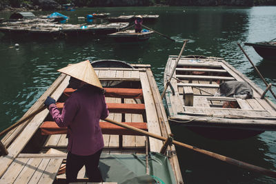 Rear view of man rowing boat in sea