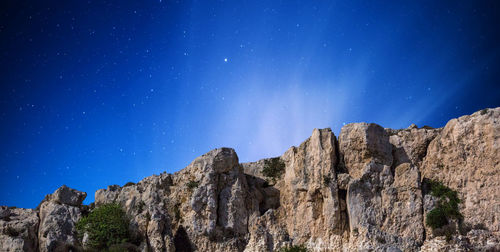 Low angle view of rock formation against clear blue sky