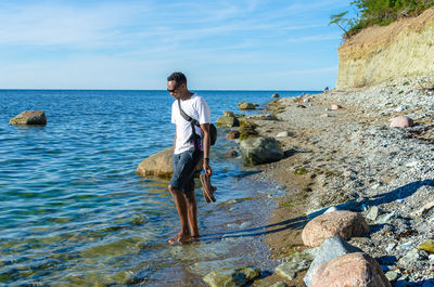 Full length of man walking at beach against sky