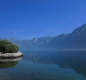 Scenic view of lake by mountains against sky