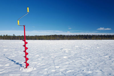 Snow covered field against blue sky