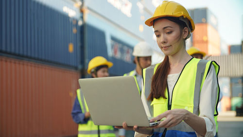 Young woman using digital tablet while sitting in office