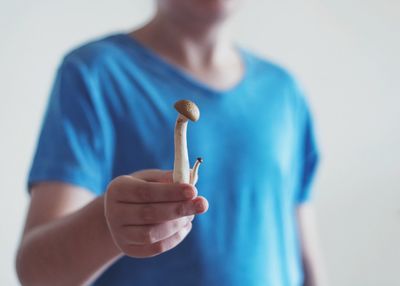 Midsection of person holding mushroom