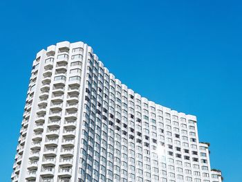 Low angle view of modern building against clear blue sky
