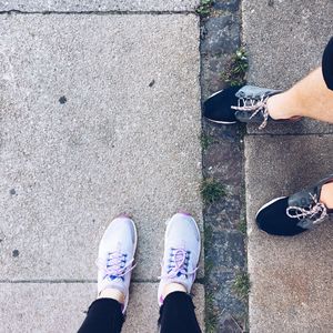 Low section of friends standing on footpath