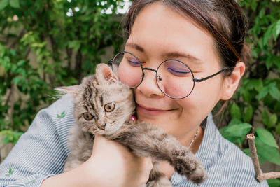 Close-up of young woman with cat