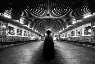 Rear view of woman walking in illuminated tunnel