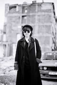 Portrait of woman wearing sunglasses standing on road