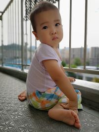 Portrait of cute baby boy sitting in balcony