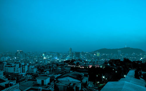 High angle view of illuminated cityscape against clear sky