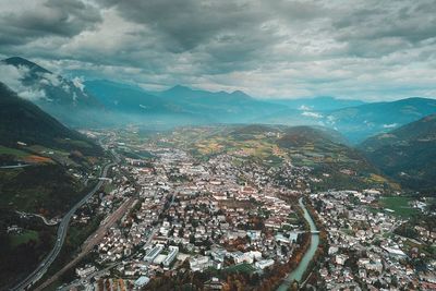 Aerial view of townscape and mountains against sky