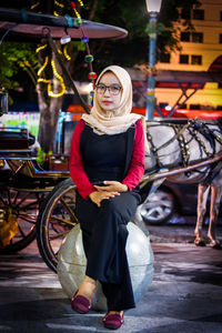 Full length portrait of young woman standing outdoors
