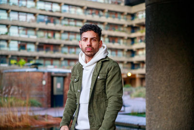 Portrait of young man standing in city