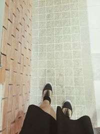 Low section of man standing on tiled floor