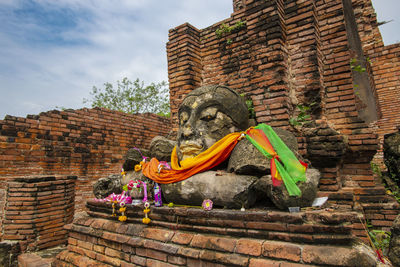 Low angle view of buddha statue against historic building