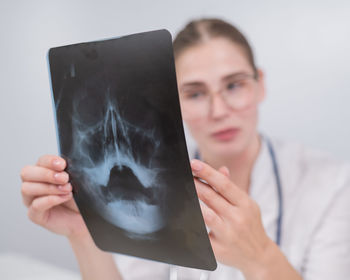 Midsection of woman using mobile phone against sky