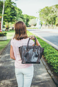 Rear view of woman walking on footpath