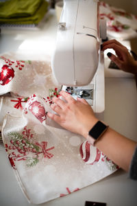 Cropped hands of woman sewing machine