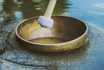 Vibrating tibetan singing bowl is floating on water 