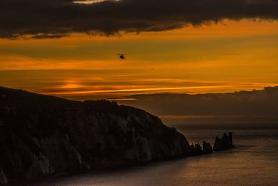 Scenic view of dramatic sky over silhouette landscape