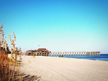 Scenic view of beach against clear blue sky