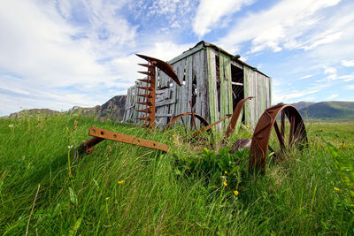 Abandoned barn on field against sky